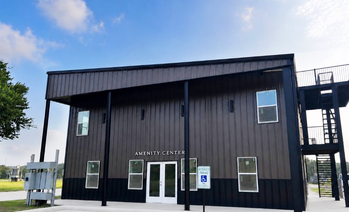 Community facility building with covered porch, washers and dryers, swimming pool, and patio balcony for parties and grilling
